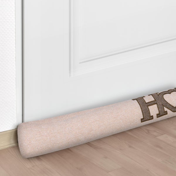 Zugluftstopper vor einer Tür auf einem Holzboden