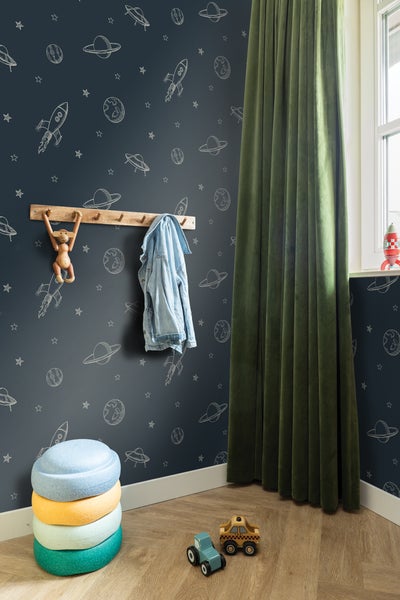 Kinderzimmer mit Weltraumtapete, Holzhakenleiste, Dekoration und Spielzeug