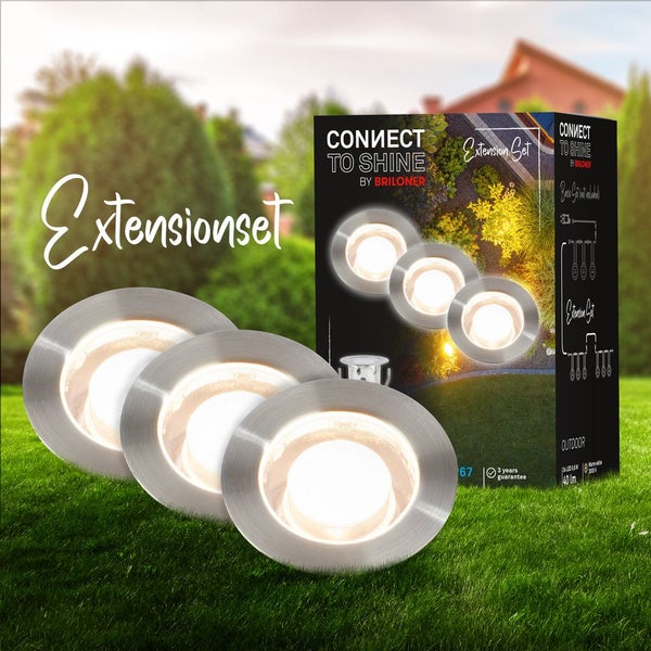 Briloner Connect to Shine Erweiterungsset mit drei runden LED-Bodeneinbaustrahlern aus Edelstahl für den Außenbereich auf einer Rasenfläche.