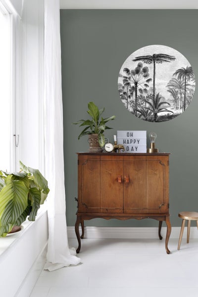 Wohnraum mit Holzschrank, Zimmerpflanzen und Wanddekoration