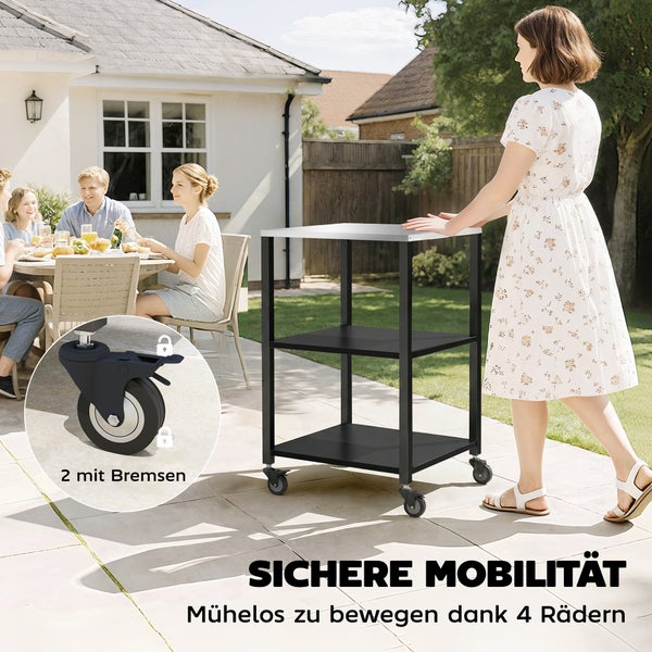 Mobiler Servierwagen aus Metall mit drei Ebenen und Edelstahl-Arbeitsplatte auf einer hellen Terrasse, vier Rollen inklusive zwei mit Feststellbremse.