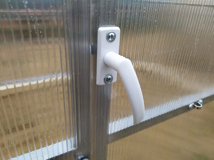 Detailansicht eines Gewächshauses mit Griff an der Tür.