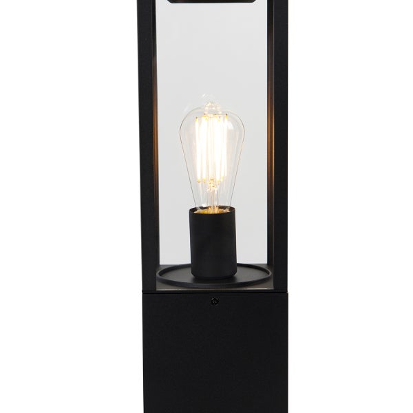 Schwarze Sockelleuchte aus Metall und Glas mit leuchtendem Filament-Leuchtmittel im modernen Design.