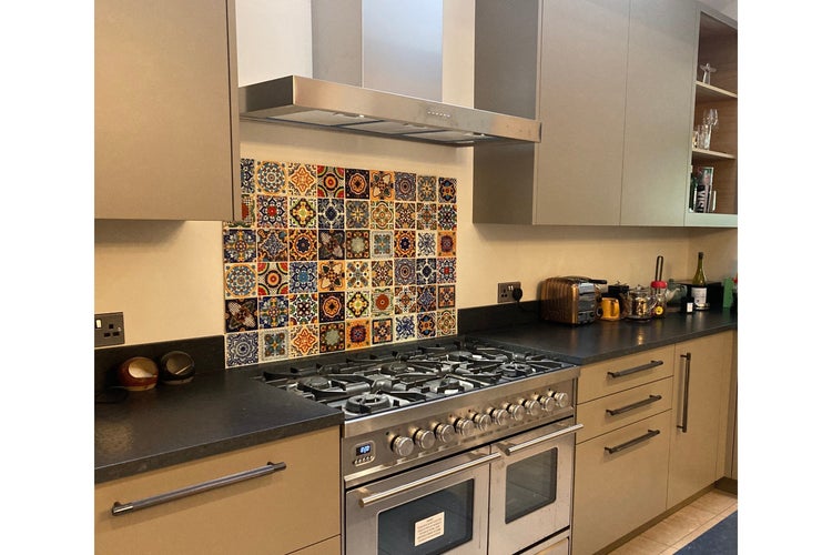 Küchenszene mit Herd, Dunstabzugshaube und Wandfliesen im Retro-Stil