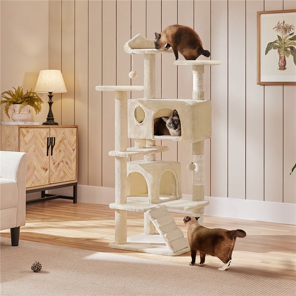 Katzenkratzbaum mit mehreren Ebenen, Höhlen und zwei Siamkatzen in einem hellen Wohnraum.
