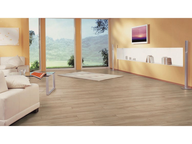 Laminatboden in heller Holzoptik in einem hellen, geräumigen Wohnzimmer mit großen Fenstern und modernen Möbeln.