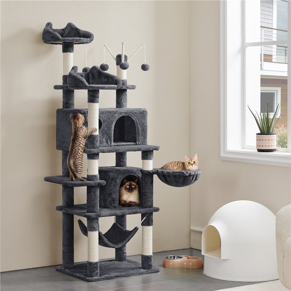 Mehrstöckiger grauer Kratzbaum mit drei Katzen, Kratzstämmen, Plattformen, Höhlen, Hängematte und Spielzeug