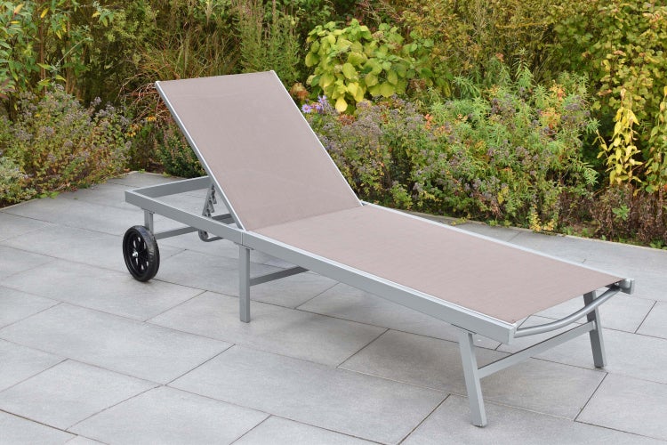 Gartensessel mit Rollen auf einer Terrasse vor Büschen