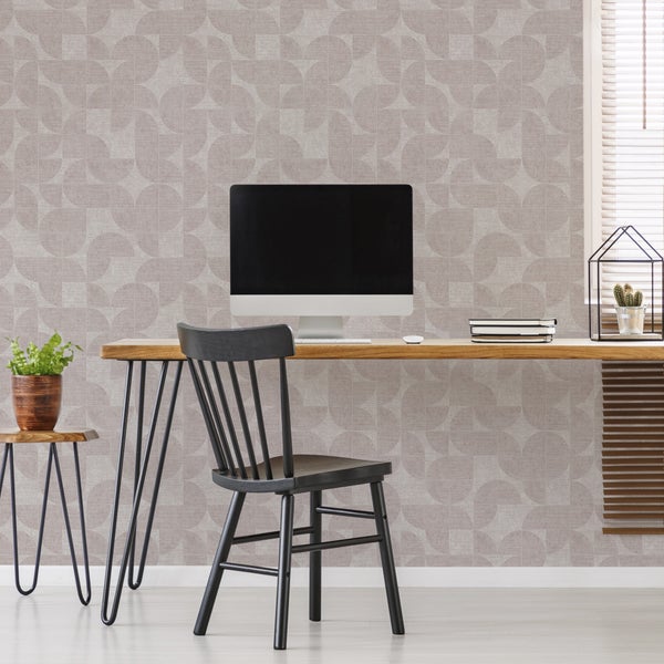 Arbeitsplatz mit Holzschreibtisch, schwarzem Stuhl und geometrisch gemusterter Tapete in Beige. Moderne und aufgeräumte Einrichtung.
