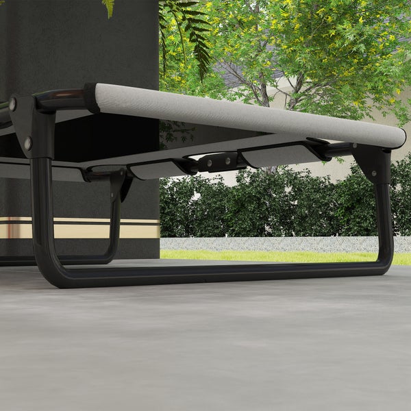 Detailansicht einer Gartenliege mit schwarzem Metallgestell und grauer Textilbespannung auf einer hellen Terrasse in einem gepflegten Garten.