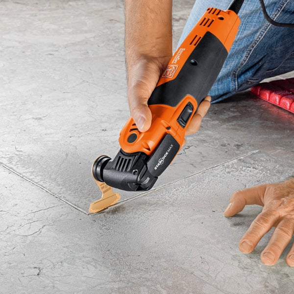 Oszillierendes Elektrowerkzeug im Einsatz auf einer Fliese