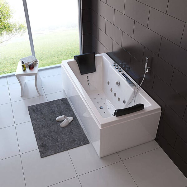Moderne Whirlpool Badewanne in einem hellen Badezimmer mit Nackenkissen Duschkopf und Massagejet Systemen an einer dunklen Fliesenwand