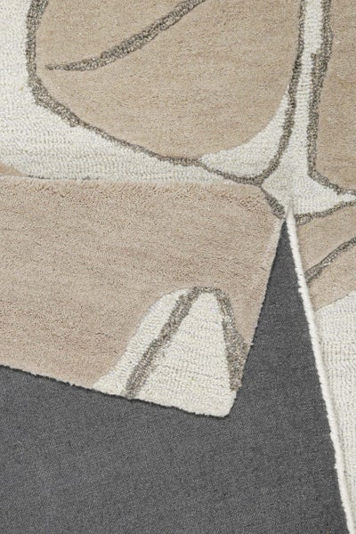 Nahaufnahme eines Teppichs mit abstrakten Mustern und verschiedenen Oberflächenstrukturen.