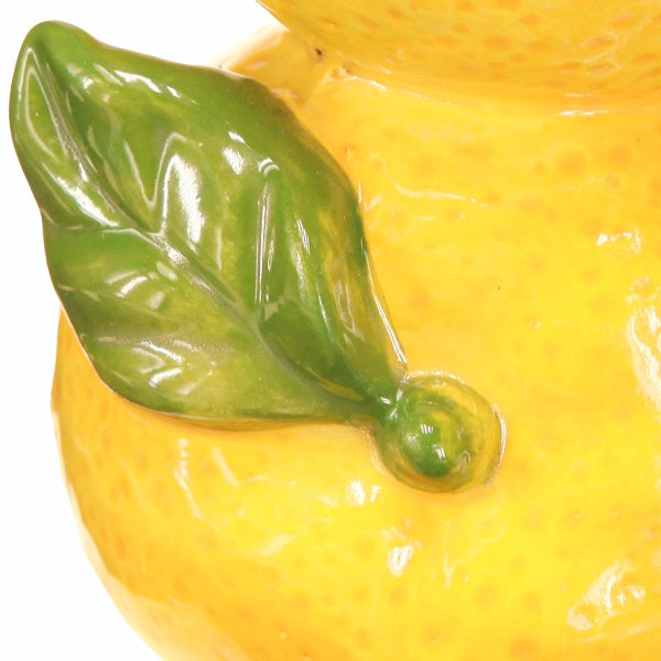 Detailansicht einer Keramik in Zitronenform mit grünem Blatt und strukturierter Oberfläche.
