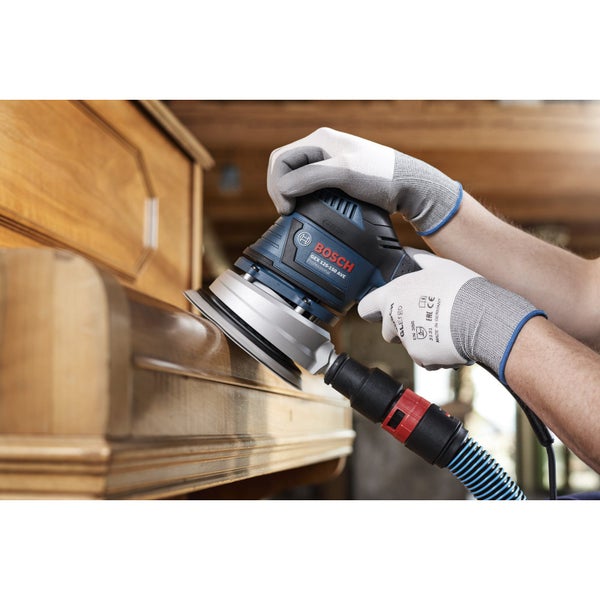 Mann schleift Holzoberfläche mit Bosch Exzenterschleifer GEX 125-150 AVE.