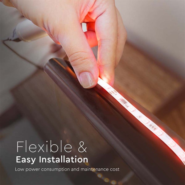 Eine Hand bringt einen flexiblen LED-Streifen an einer Möbelkante an.