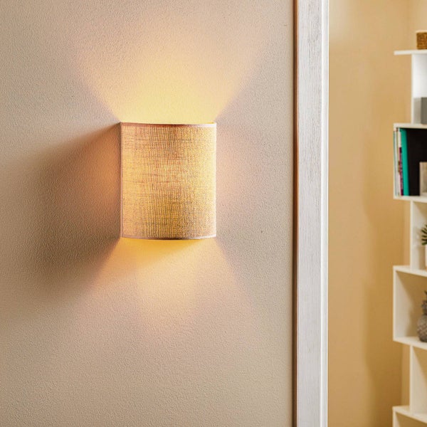 Wandleuchte mit halbrundem Stoffschirm in Leinen-Optik, strahlt Licht nach oben und unten an die Wand ab.