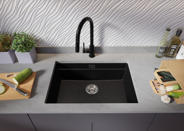 Küchenspüle mit Armatur, Schneidebrett, Gemüse und Kräutern auf der Arbeitsplatte