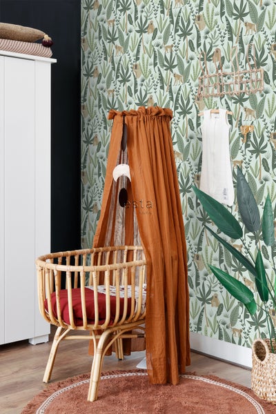 Kinderzimmer mit Rattanbett und Baldachin vor Dschungeltapete