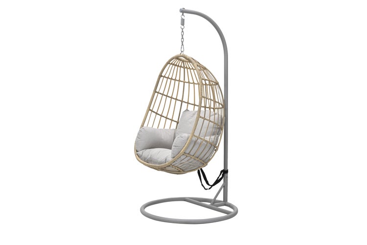 Freistehender Hängesessel aus beigem Polyrattan mit grauem Metallgestell und hellgrauen Kissen.