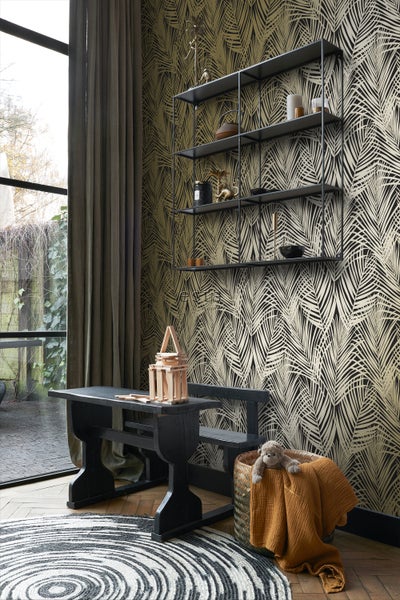 Zimmer mit gemusterter Tapete, Regal, Tisch und Dekorationen.