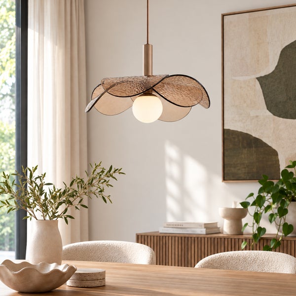 Moderne Pendelleuchte in Blumenform mit Glasblättern und Kugelglas über einem Holzesstisch in einem hellen, wohnlichen Esszimmer.
