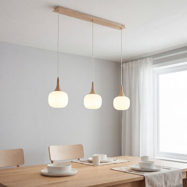 Dreiflammige Pendelleuchte mit weißen Glasschirmen und Holzelementen über einem Esstisch aus Holz in einem hellen Raum.
