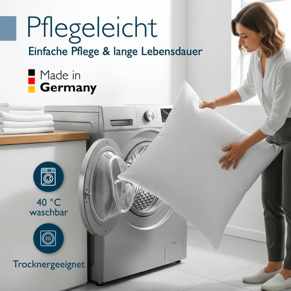 Eine Frau bezieht ein Bett mit einem weißen Kopfkissen von Beautissu in einem hellen Schlafzimmer mit Made in Germany und Nomite Zertifizierung.