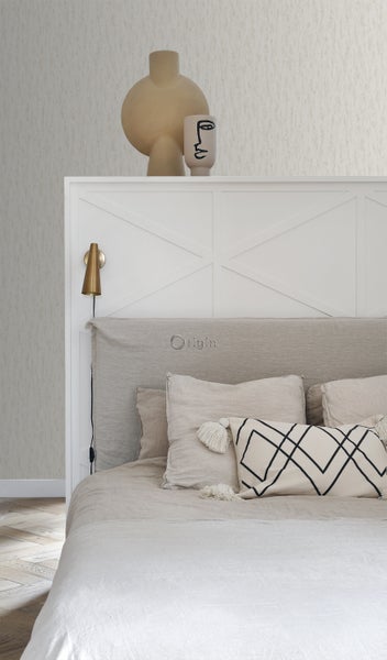 Schlafzimmerszene mit Bett, Nachttischlampe und Dekorationsartikeln