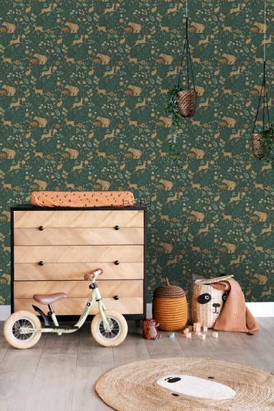 Kinderzimmer mit Kommode, Laufrad, Spielzeug und Tapete mit Tiermotiven