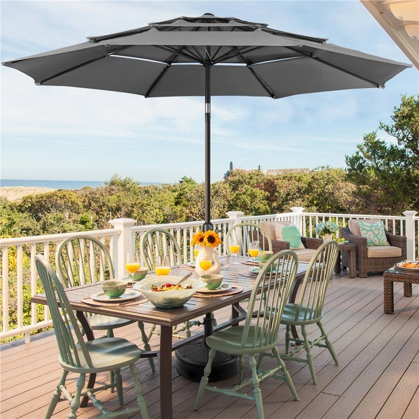 Terrasse mit Esstisch, Stühlen und großem Sonnenschirm für den Außenbereich