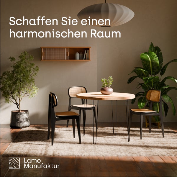 Moderner Essbereich mit rundem Holztisch, drei schwarzen Stühlen mit Wiener Geflecht, Zimmerpflanzen und einem Teppich. Lamo Manufaktur Logo.