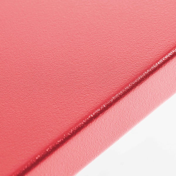 Nahaufnahme einer roten, strukturierten Oberfläche mit abgerundeter Kante.