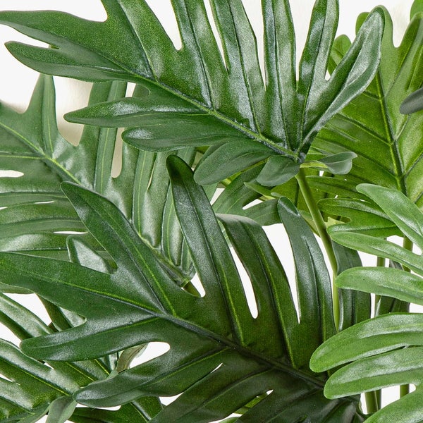 Künstliche Blume mit gelben trichterförmigen Blüten und grünen Blättern an einem verzweigten Stängel.