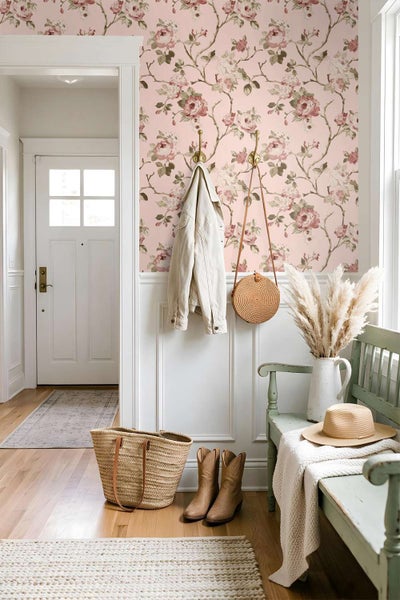 Eingangsbereich mit Blumenmustertapete, weisser Wandverkleidung, Holzbank, Kleiderhaken und Dekoration im Landhausstil.
