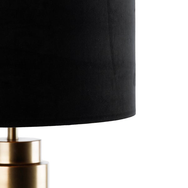 Detailansicht einer Tischleuchte mit schwarzem Lampenschirm und goldenem Lampenfuß