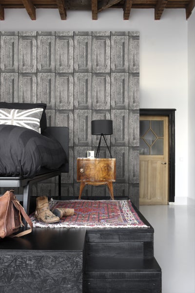 Schlafzimmer mit Bett, Nachttisch und Wandtapete in Holzoptik