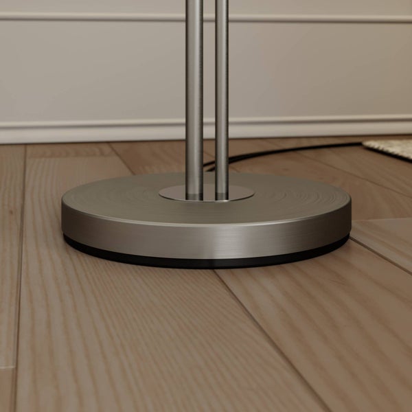 Detailansicht des Metallsockels einer Stehlampe auf einem Holzboden
