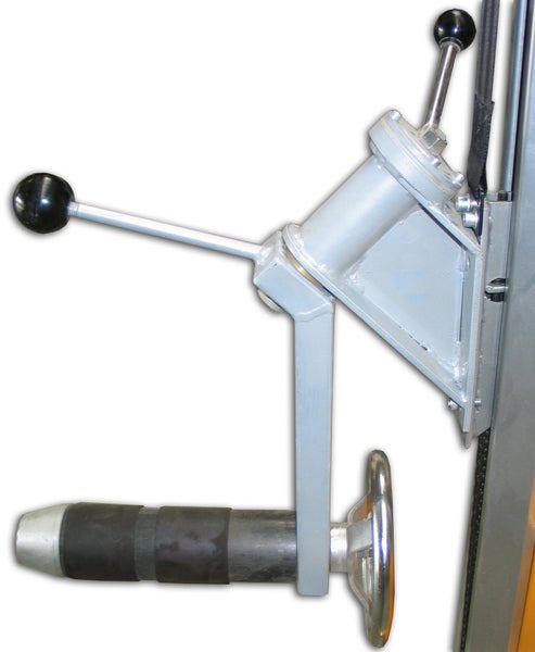 Maschinenteil aus grauem Metall mit zwei Hebeln mit schwarzen Knäufen und einem silbernen Handrad.