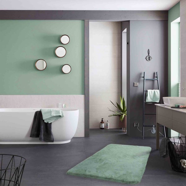 Badezimmer mit Badewanne, Spiegeln und Badteppich