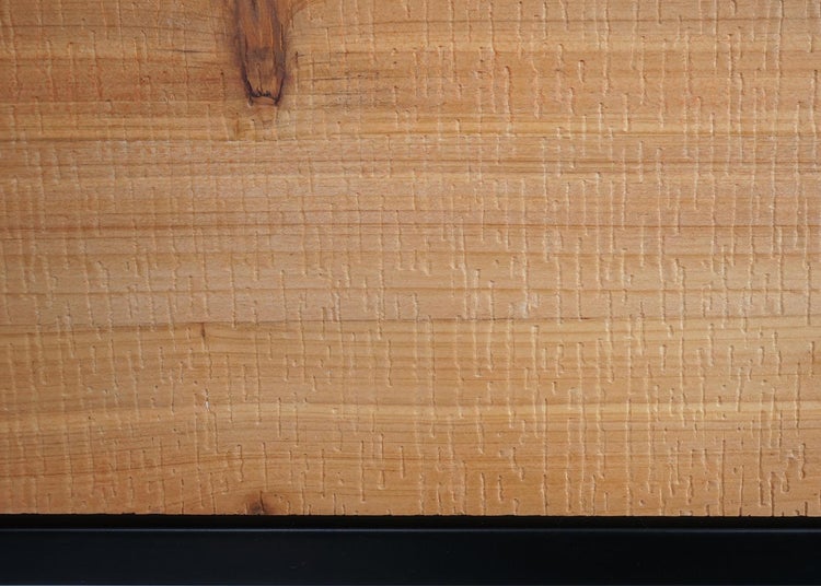 Detailaufnahme einer strukturierten Holzoberfläche mit Bandsägespuren und sichtbarem Astloch.