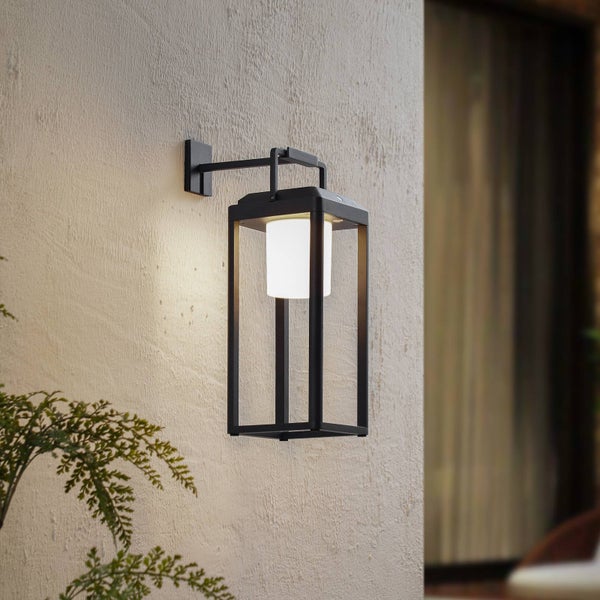 Moderne Außenwandleuchte in Laternenform aus schwarzem Metall an einer strukturierten Fassade.