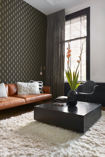 Wohnzimmer mit Ledersofa, Couchtisch, Teppich und gemusterter Tapete