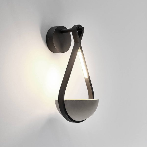 Schwarze Wandleuchte in Tropfenform aus Metall und grauem Beton mit integriertem LED-Licht.