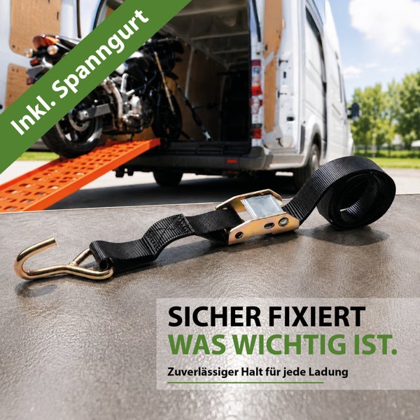 Spanngurt mit Ratsche und Haken zur Ladungssicherung, im Hintergrund ein Motorrad auf einer Rampe an einem Transporter.