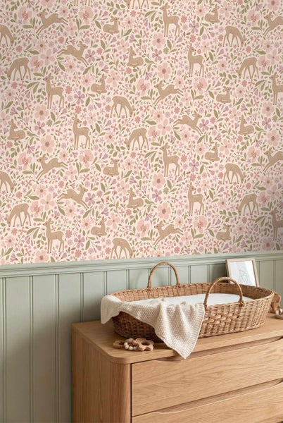 Kindertapete mit Waldmotiven und Rehen sowie Blumenmuster im Babyzimmer mit Holzkommode und Wickelkorb