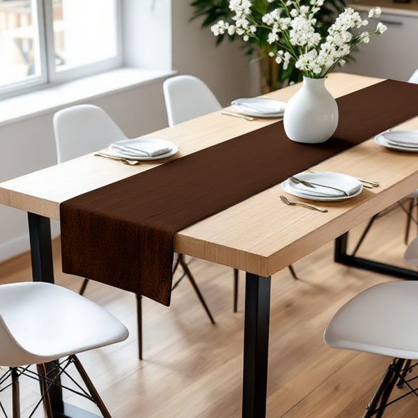 Esstisch mit braunem Tischläufer, Geschirr und Blumenvase