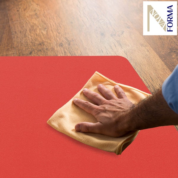 Kugel-Ilex in terrakottafarbenen Pflanztöpfen auf einem Transportwagen und auf Kiesboden in einem Gartencenter.