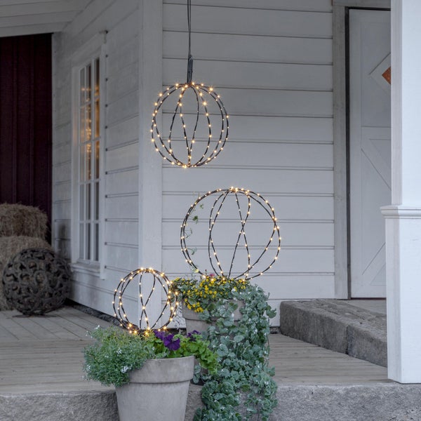 Dekorative Leuchtkugeln mit LED-Lichtern vor einem Haus