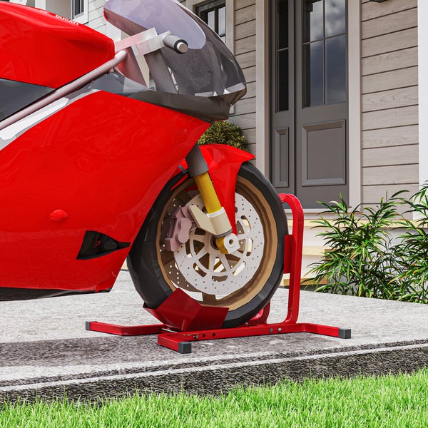 Motorradwippe für das Vorderrad aus Metall fixiert ein Motorrad mit Ducati Logo auf einem hellen gepflasterten Untergrund vor einem Hauseingang.